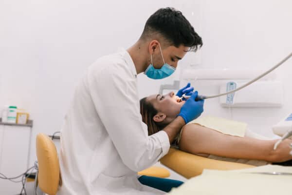 dental assistant cleaning a woman's teeth in a dental office